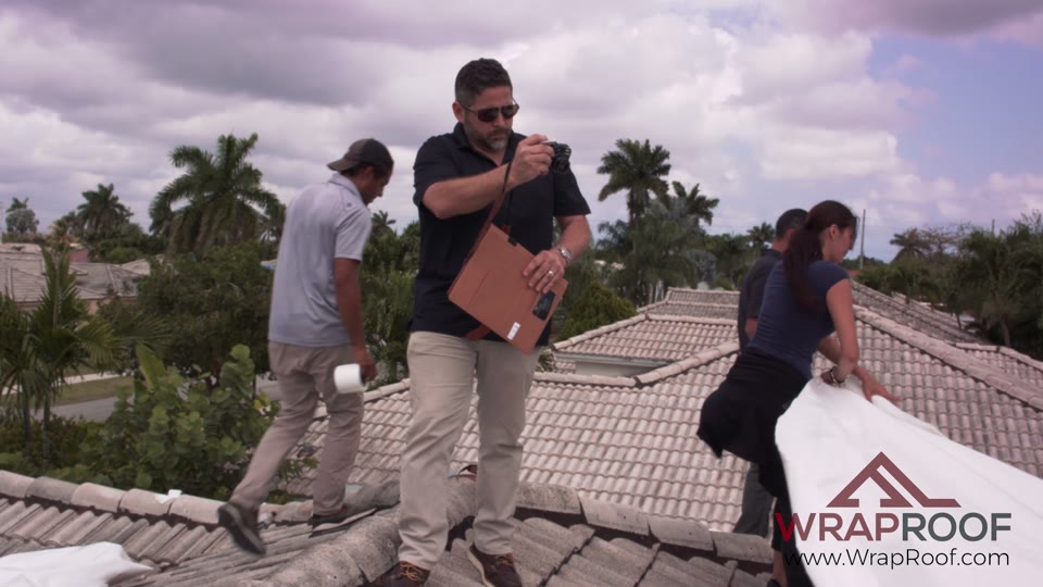 Wraproof team and adjuster inspecting a tile roof during a mid-claim visit